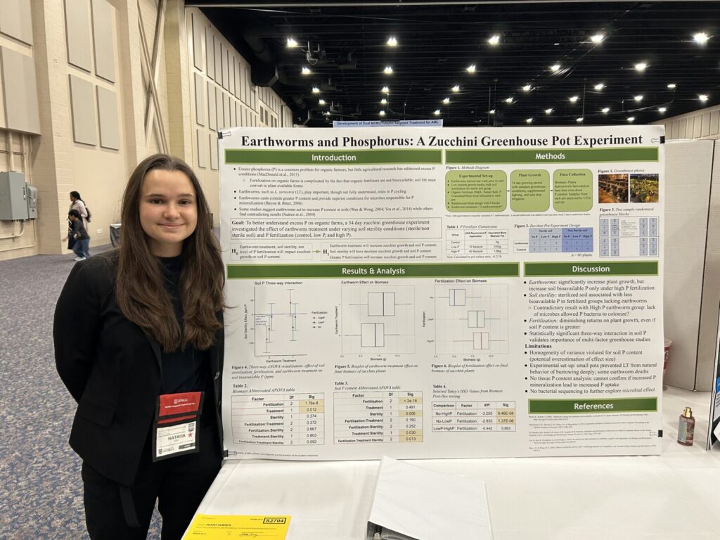 Girl standing next to science fair poster in convention hall